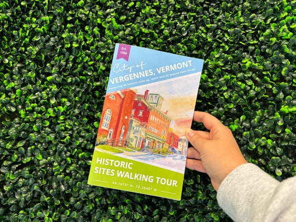 A physical copy of the Vergennes Historic Walking Tour in front of boxwood