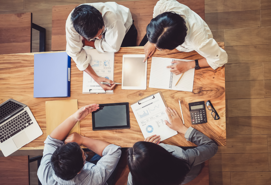 An overhead shot of four people collaborating at a table.